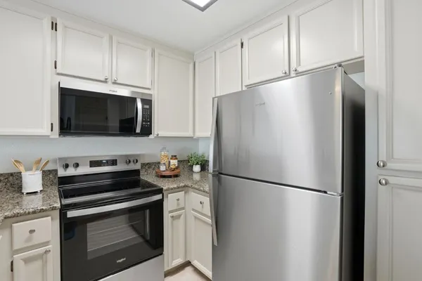 a kitchen with stainless steel appliances a refrigerator a sink a stove a microwave and cabinets