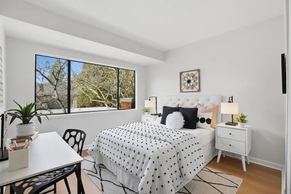 a bedroom with a bed and a table in it with window