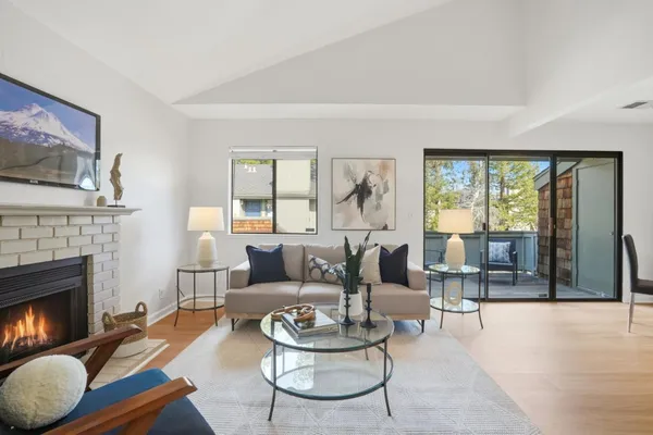 a living room with furniture a fireplace and a large window
