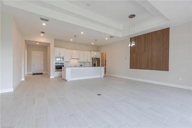 a view of kitchen with kitchen island a sink stainless steel appliances and white cabinets
