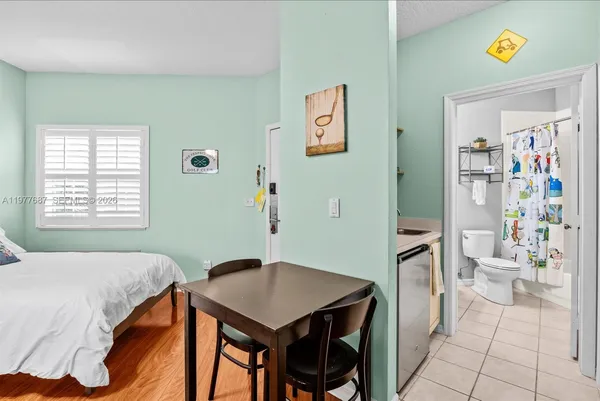 a kitchen with a sink and a stove with wooden floor
