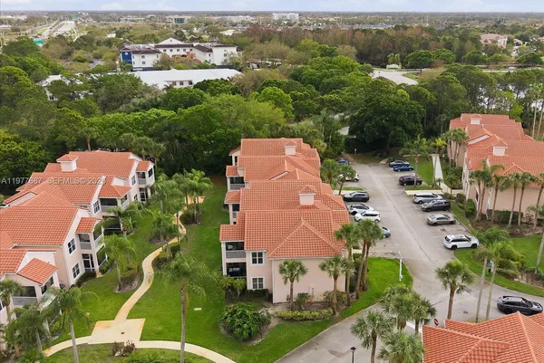 an aerial view of residential houses with outdoor space and trees