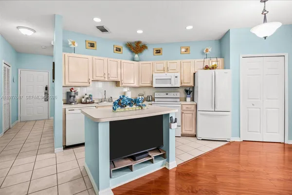 a kitchen with stainless steel appliances granite countertop a refrigerator sink and white cabinets