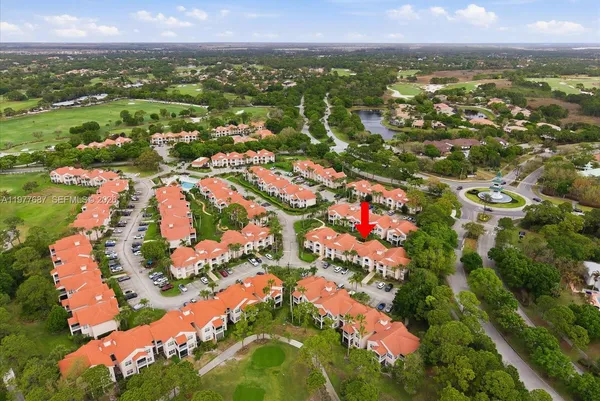 an aerial view of a residential houses with outdoor space and a lake view