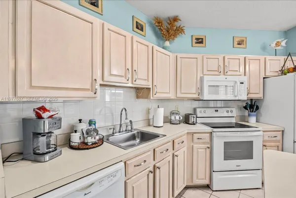 a kitchen with white cabinets and white appliances