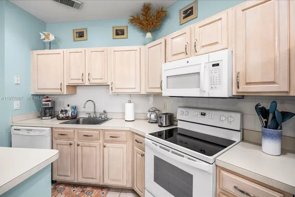 a kitchen with stainless steel appliances white cabinets and a sink