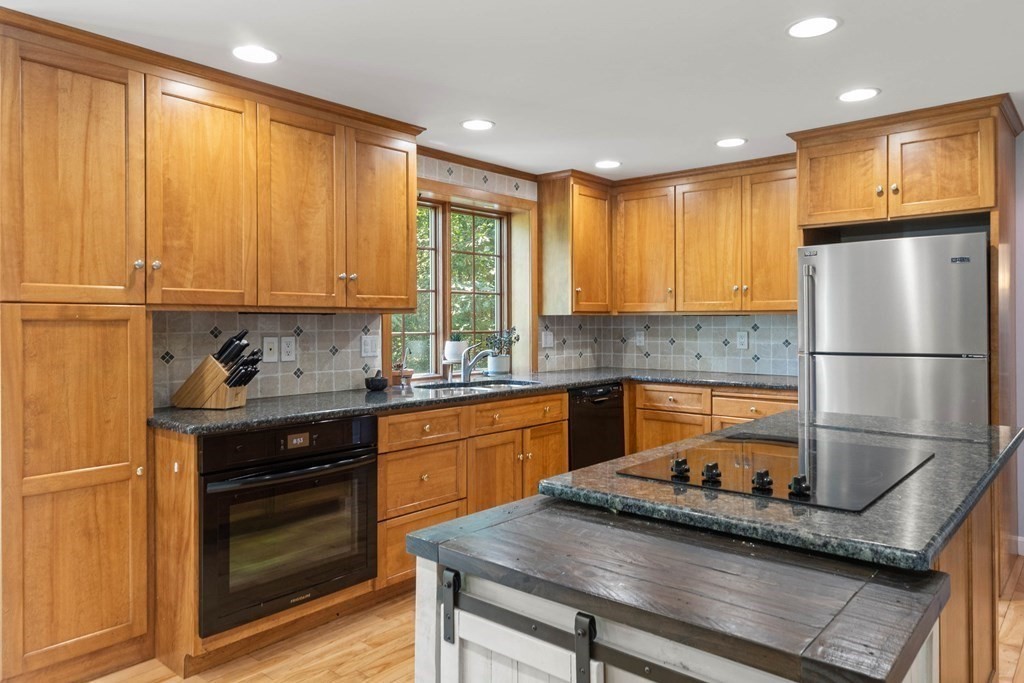 105 Valley Road Boxford, MA 01921 - Photo 3 of 41 a kitchen with kitchen island granite countertop a sink stainless steel appliances and cabinets