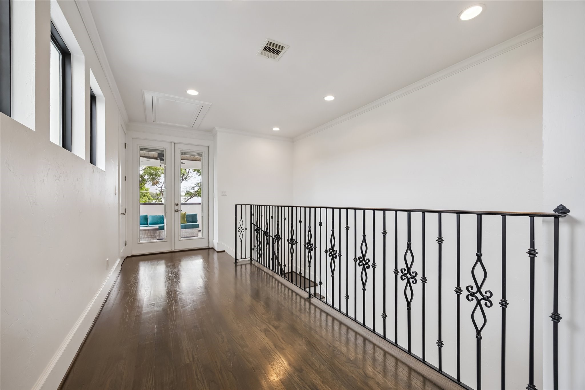 1208 Welch Street Houston, TX 77006 - Photo 25 of 35 At the top of the stairs is a hallway between the covered patio and the second living space. There's plenty of width for a wall of bookcases or a home office.