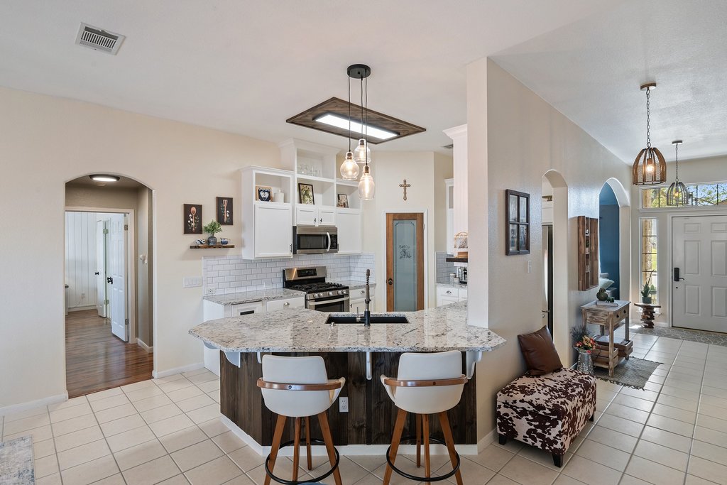 2305 Candle Ridge Trail Georgetown, TX 78626 - Photo 12 of 40 Kitchen featuring arched walkways, white cabinets, light stone countertops, light tile patterned floors, and open shelves