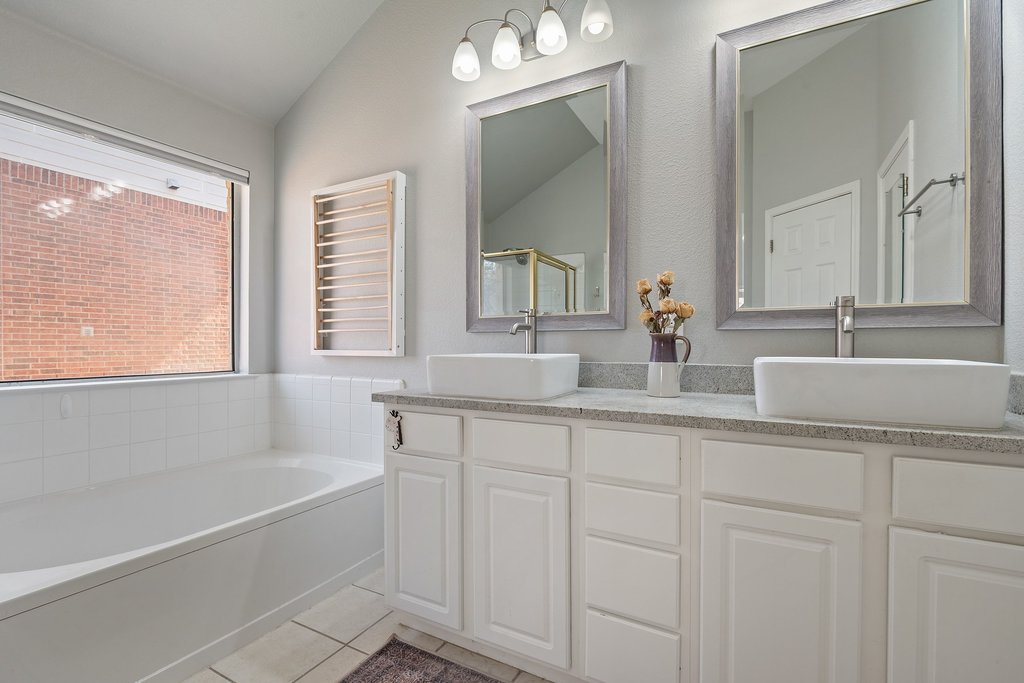 2305 Candle Ridge Trail Georgetown, TX 78626 - Photo 21 of 40 Full bathroom with double vanity, a garden tub, radiator, light tile patterned floors, and lofted ceiling