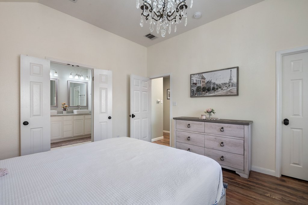 2305 Candle Ridge Trail Georgetown, TX 78626 - Photo 26 of 40 Bedroom featuring dark wood finished floors and a chandelier