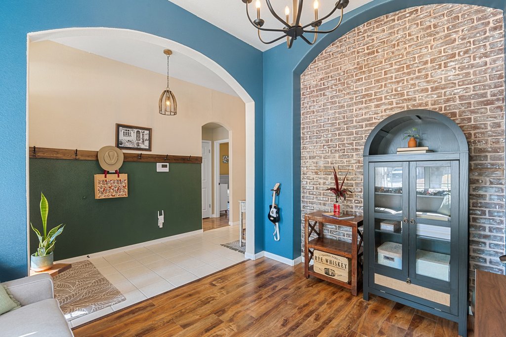 2305 Candle Ridge Trail Georgetown, TX 78626 - Photo 3 of 40 Foyer with wood finished floors, a chandelier, brick wall, and arched walkways