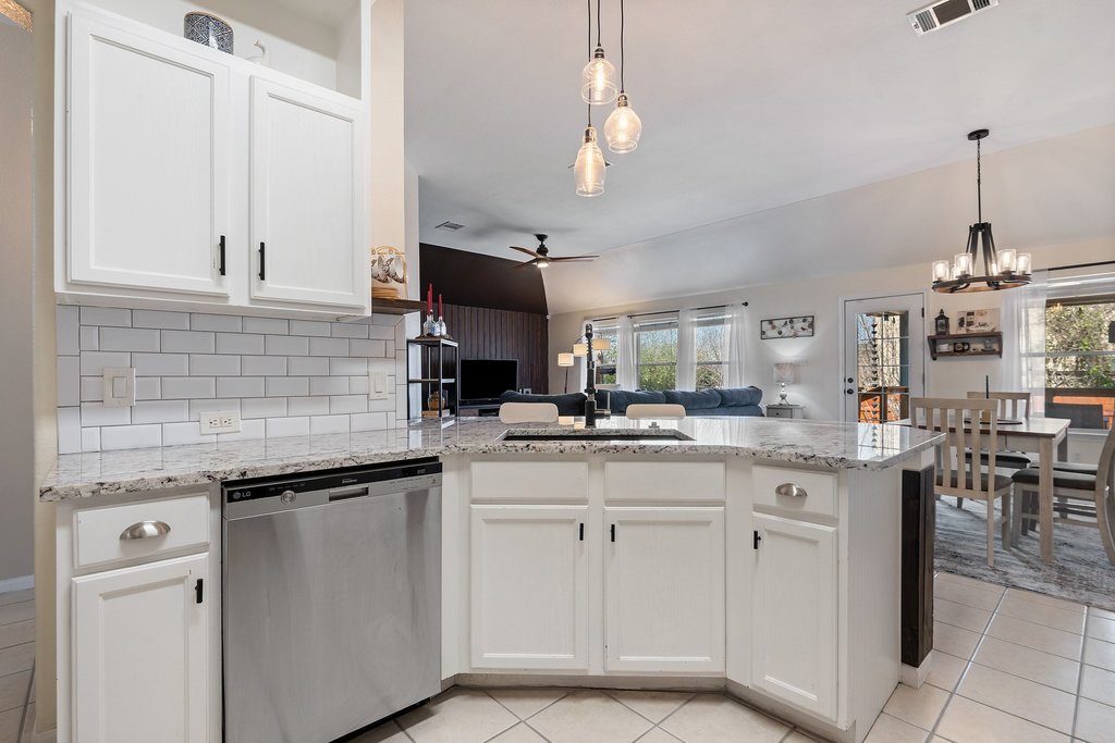 2305 Candle Ridge Trail Georgetown, TX 78626 - Photo 40 of 40 Kitchen with dishwasher, a peninsula, white cabinetry, light stone counters, and open floor plan