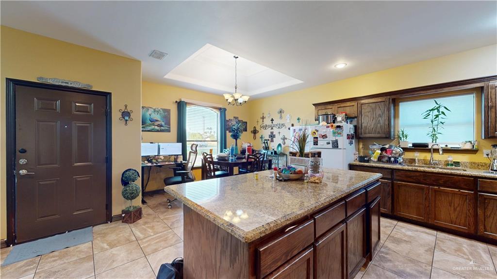 731 North Tower Road Alamo, TX 78516 - Photo 20 of 28 a kitchen with a stove a sink a counter top space and living room view