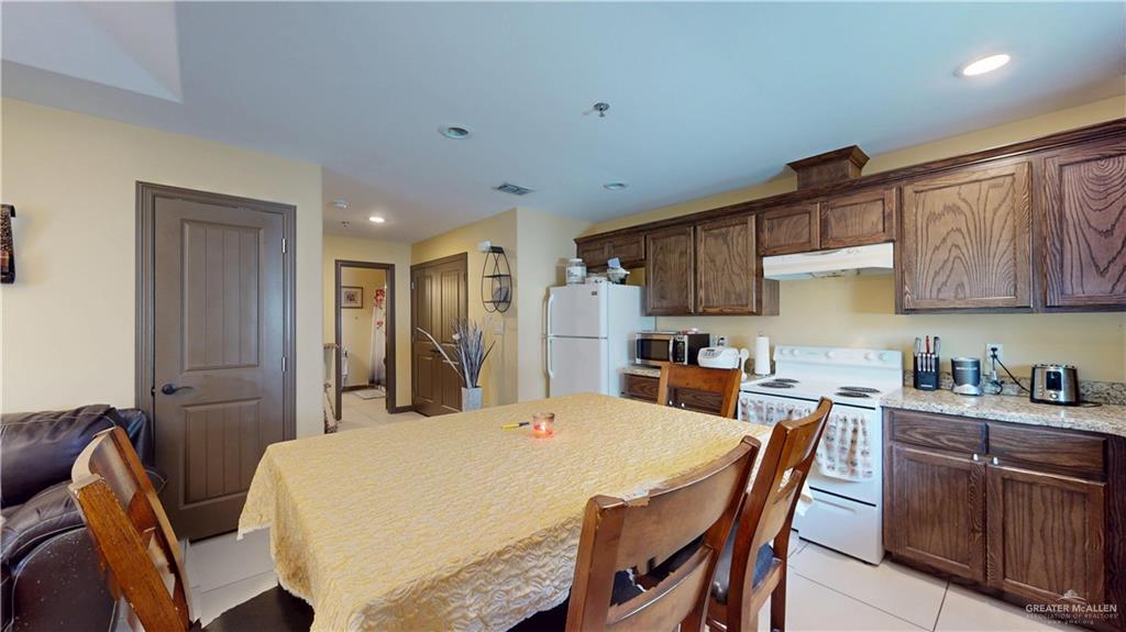 731 North Tower Road Alamo, TX 78516 - Photo 23 of 28 a kitchen with stainless steel appliances kitchen island granite countertop a dining table chairs and a refrigerator