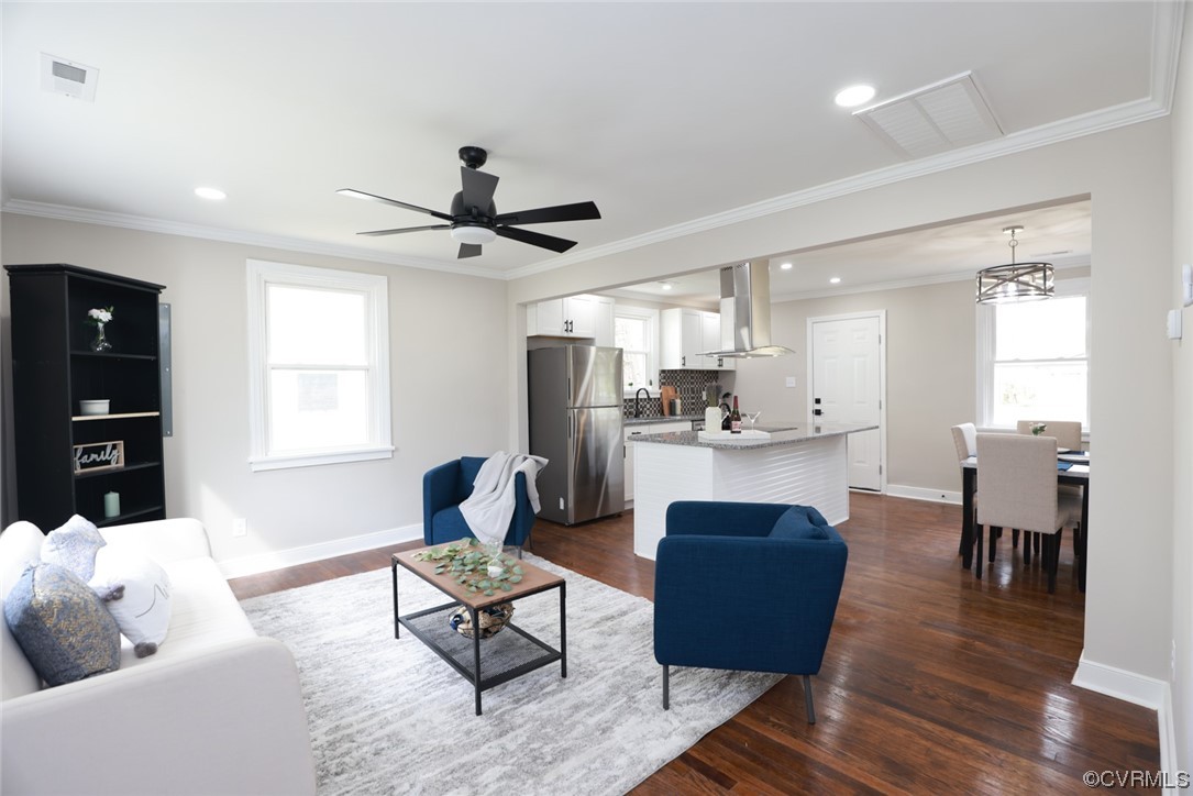 2305 Wright Avenue Richmond, VA 23224 - Photo 2 of 33 a living room with couches a dining table and kitchen view with wooden floor