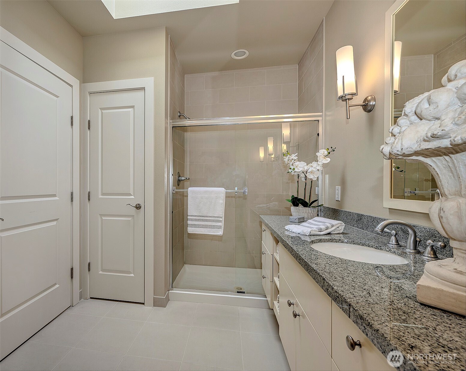 61 Pine Street, Unit 201 Edmonds, WA 98020 - Photo 18 of 34 a bathroom with a granite countertop sink a mirror and a shower