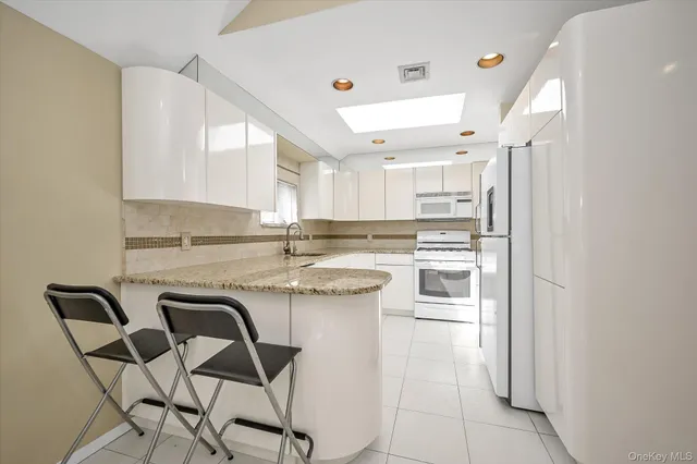 a kitchen with kitchen island a stove a table and chairs