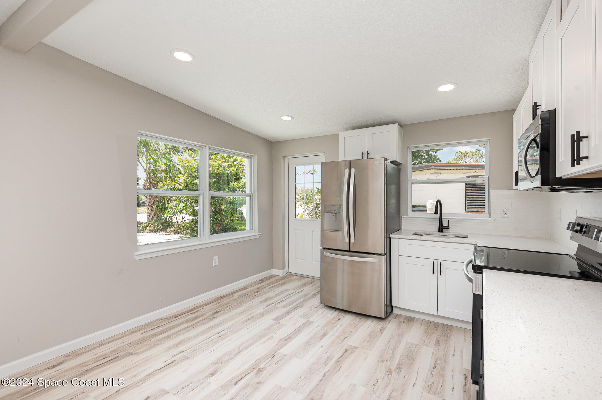 2626 Sarno Road Melbourne, FL 32935 - Photo 13 of 24 a kitchen with stainless steel appliances a refrigerator sink and microwave