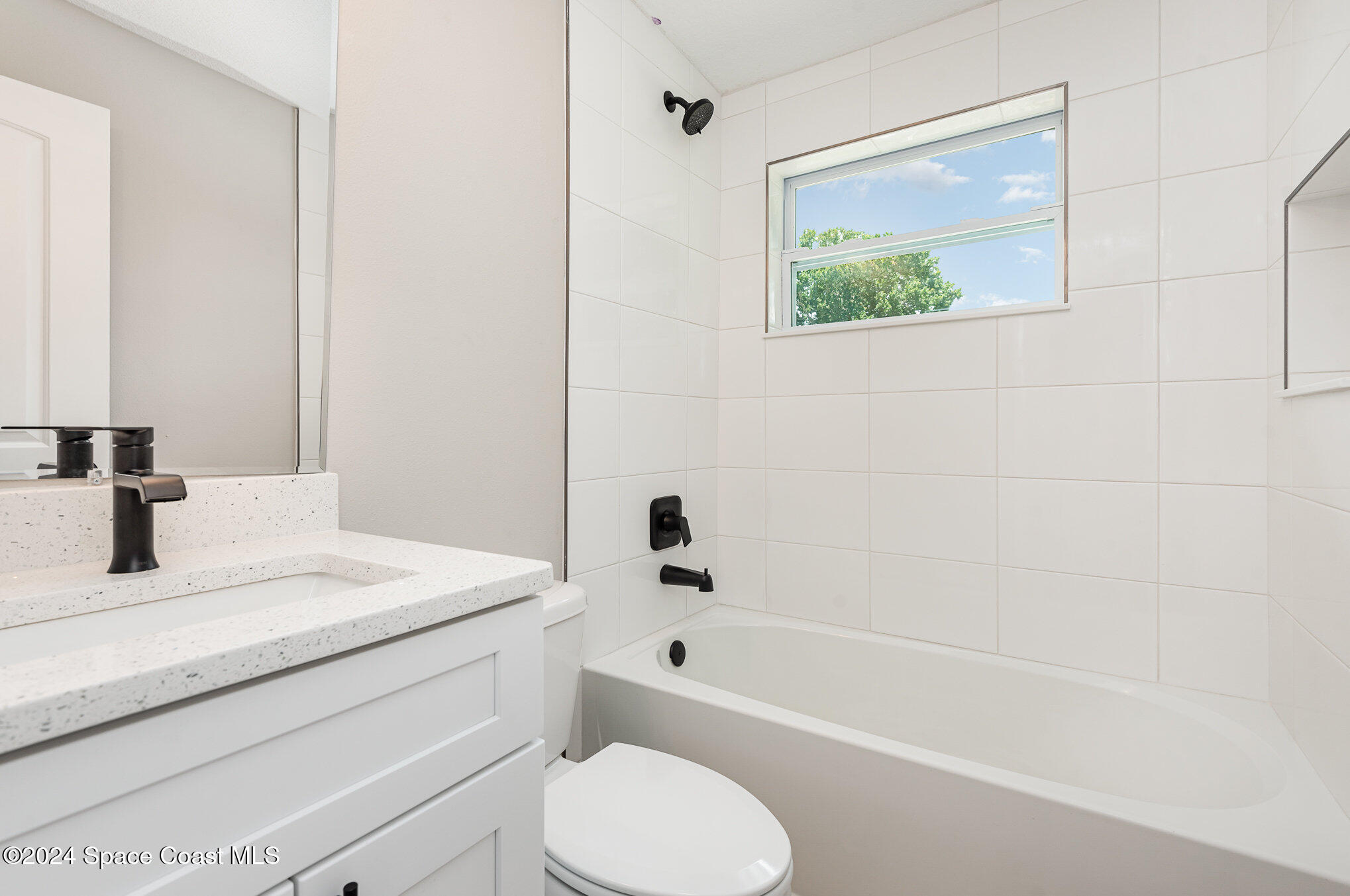 2626 Sarno Road Melbourne, FL 32935 - Photo 15 of 24 a bathroom with a granite countertop toilet a sink and a bathtub