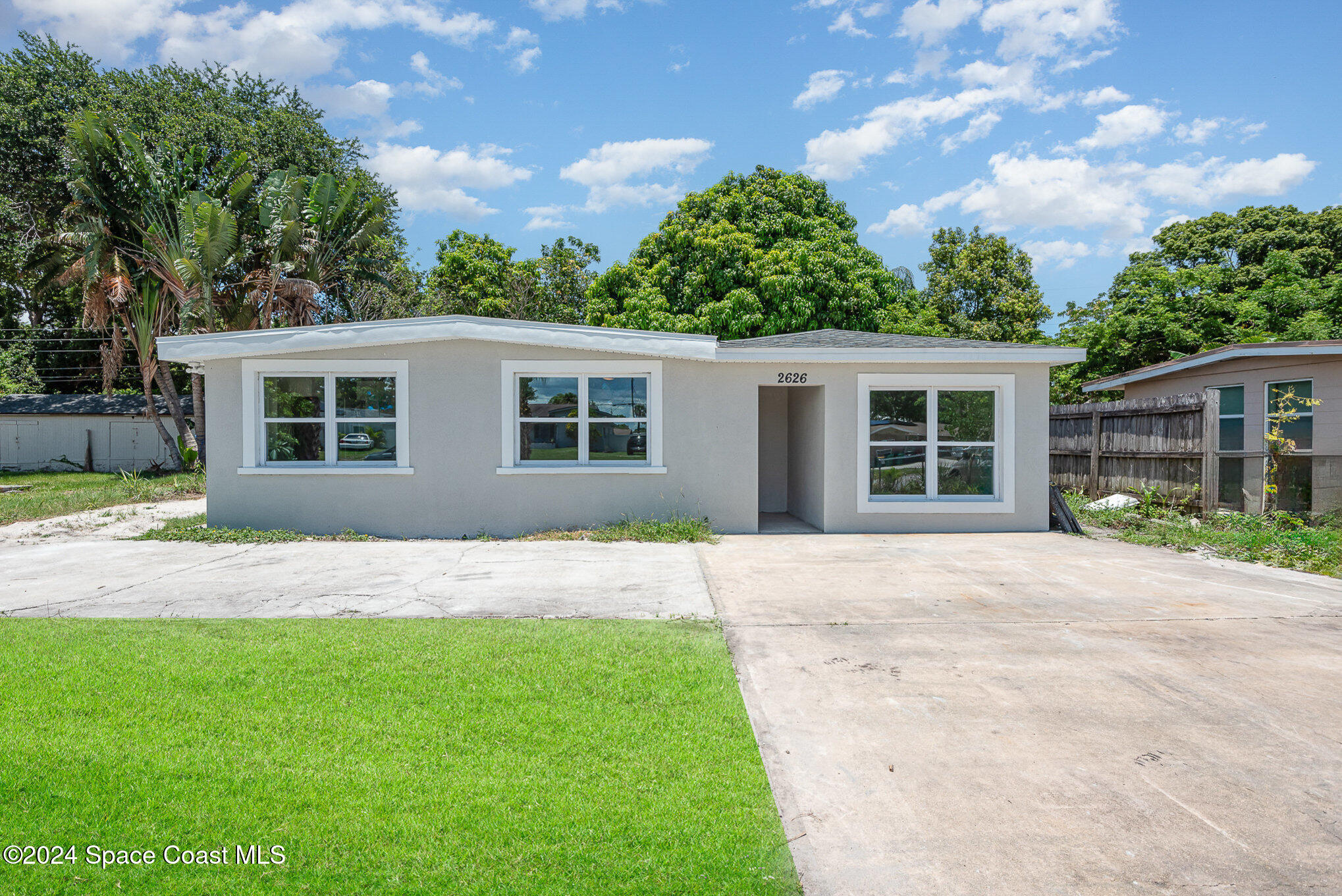 2626 Sarno Road Melbourne, FL 32935 - Photo 18 of 24 front view of a house with a yard and potted plants