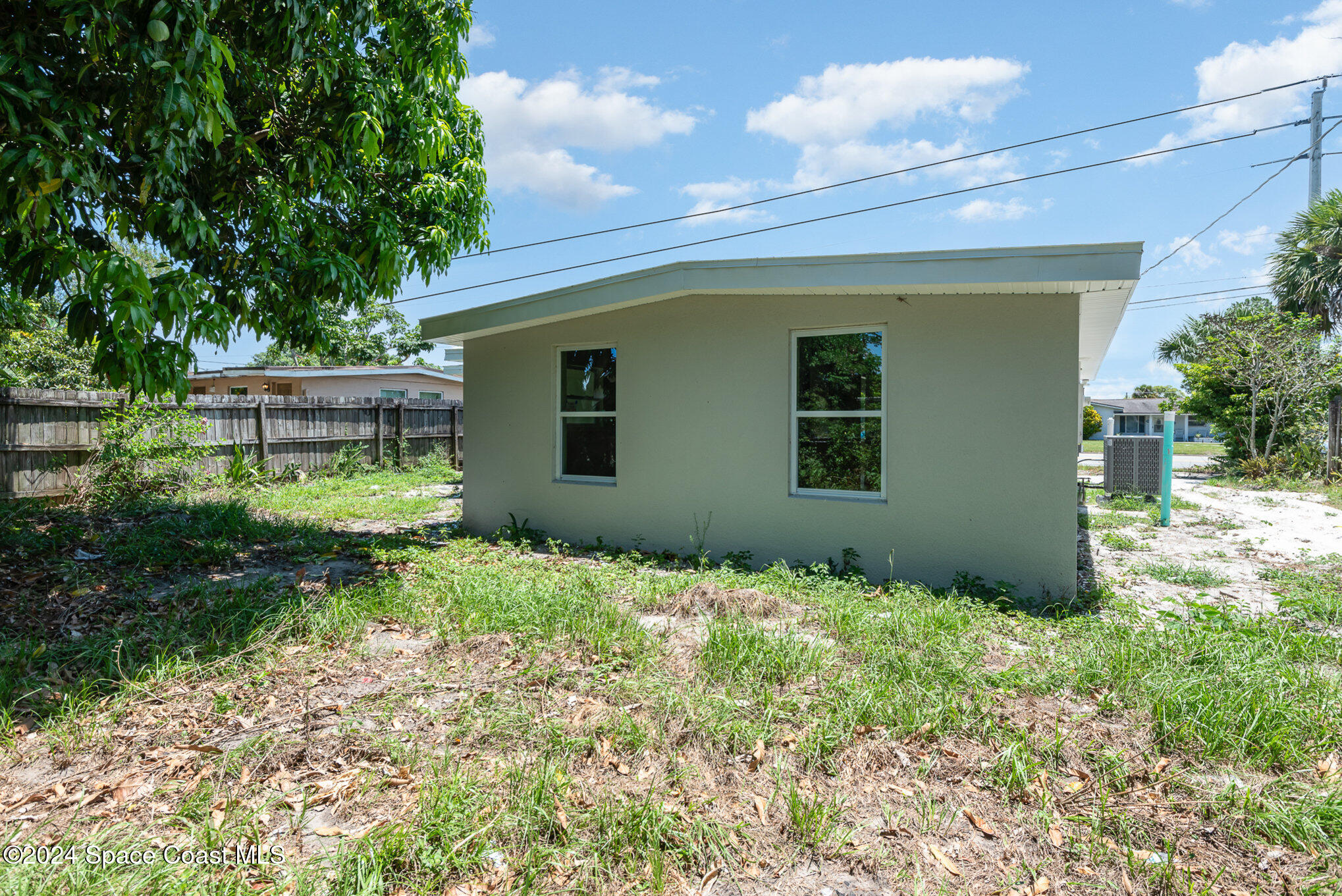 2626 Sarno Road Melbourne, FL 32935 - Photo 22 of 24 a backyard of a house with plants and large tree