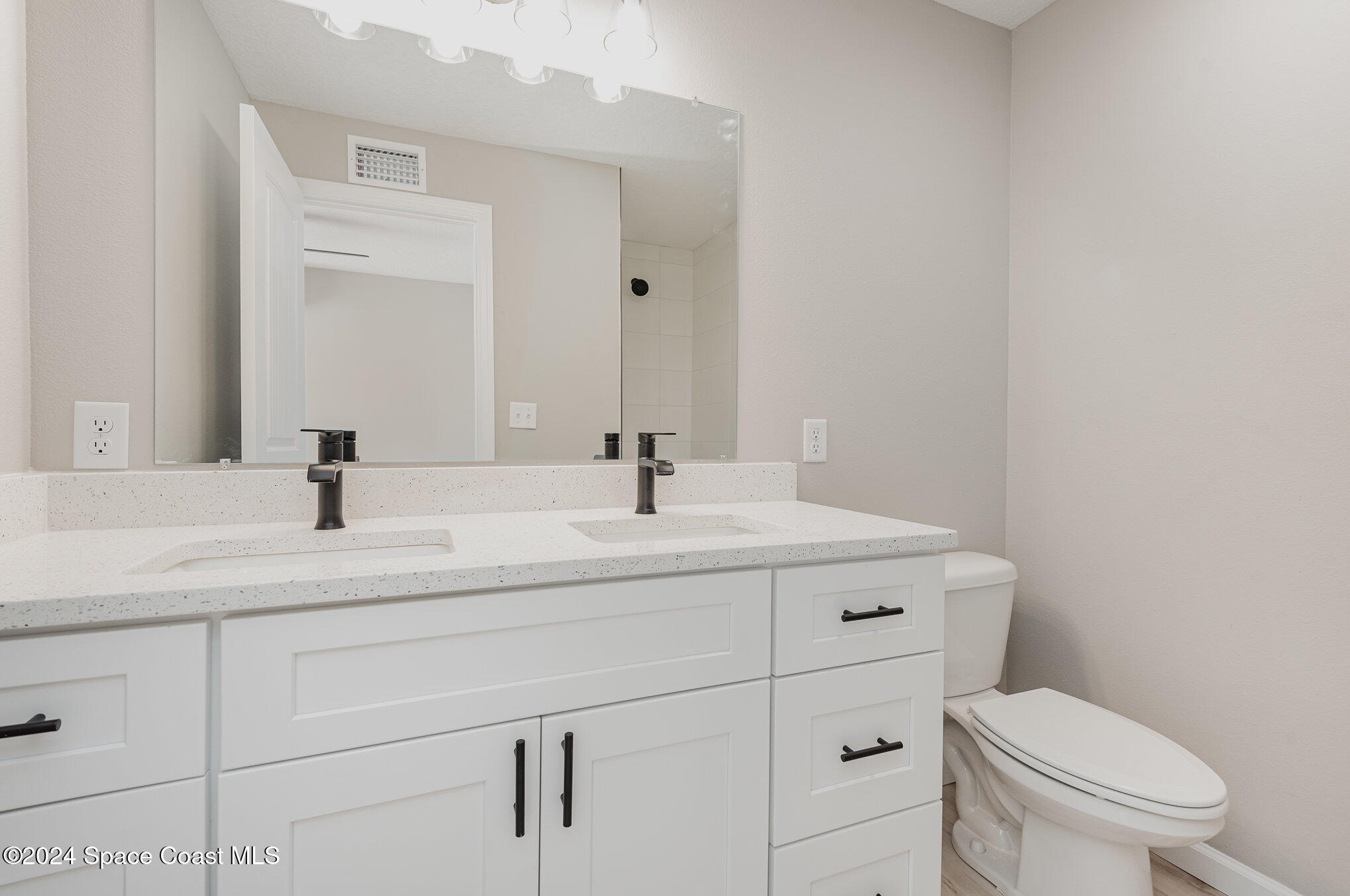 2626 Sarno Road Melbourne, FL 32935 - Photo 6 of 24 a bathroom with a sink a toilet and a mirror