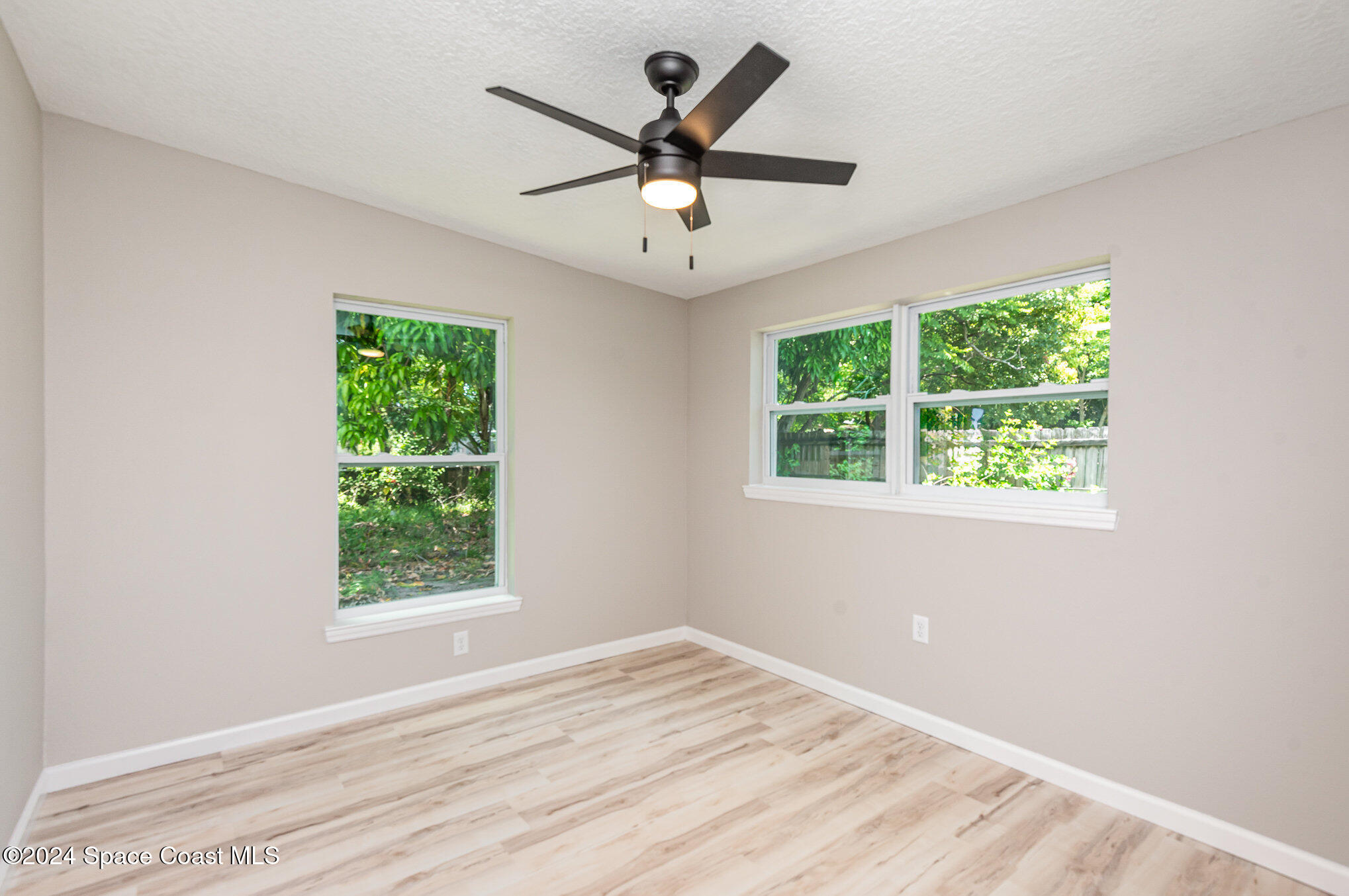 2626 Sarno Road Melbourne, FL 32935 - Photo 8 of 24 an empty room with window and ceiling fan