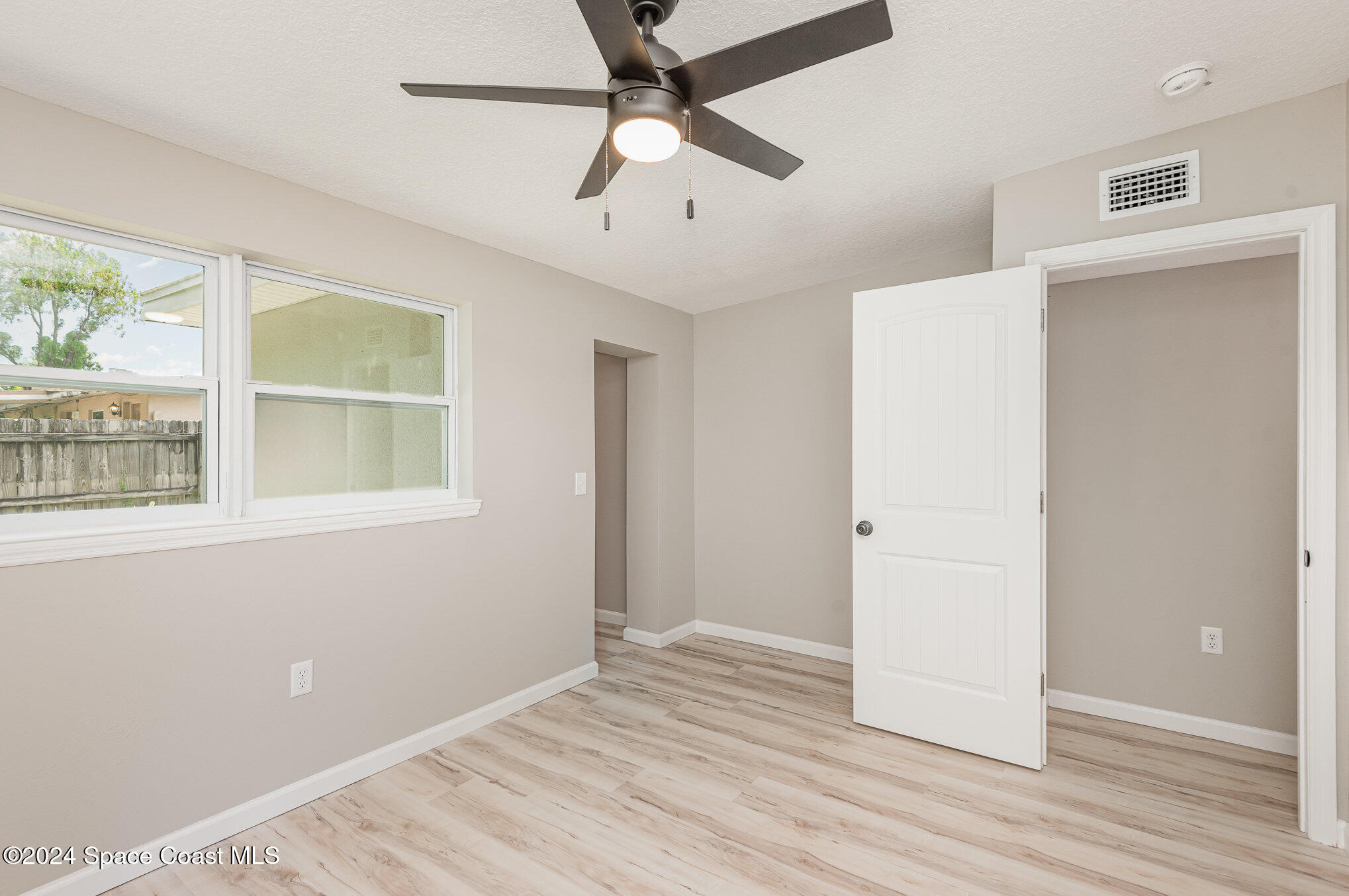 2626 Sarno Road Melbourne, FL 32935 - Photo 9 of 24 a view of an empty room with wooden floor and a window