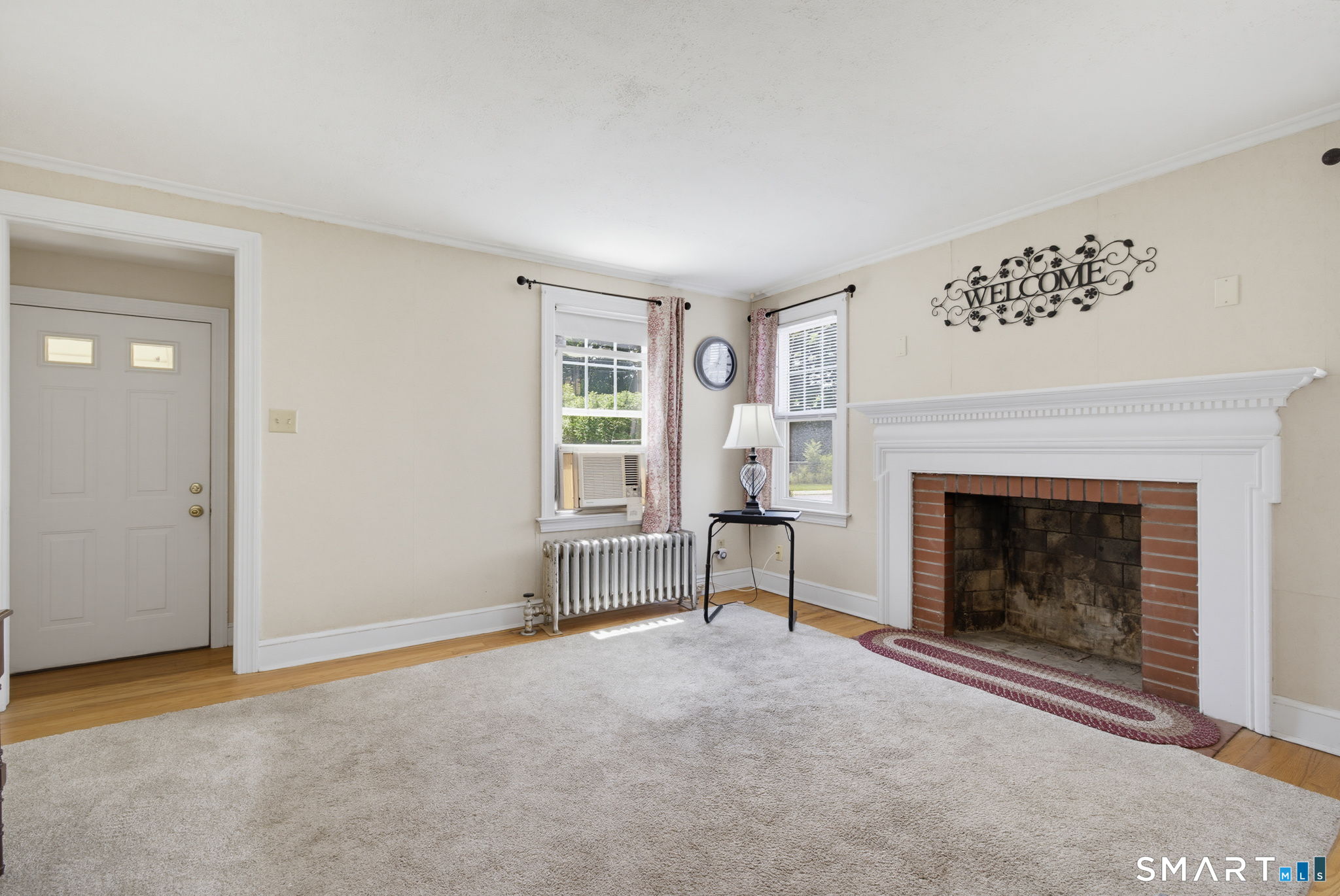 417 Hartford Road Manchester, CT 06040 - Photo 12 of 38 Living room with brick fireplace with wood mantle.