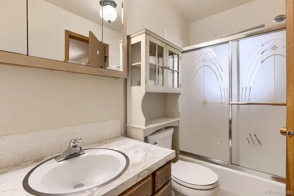 a bathroom with a sink a toilet and shower