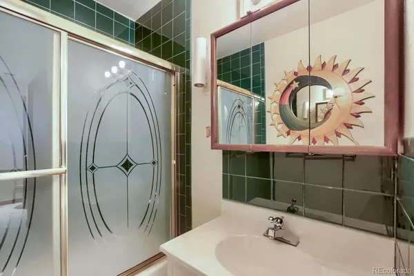 a bathroom with a sink a mirror and shower