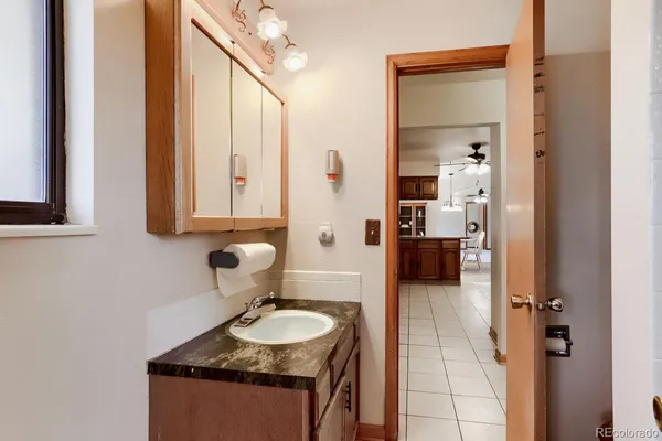 a bathroom with a granite countertop sink and a mirror