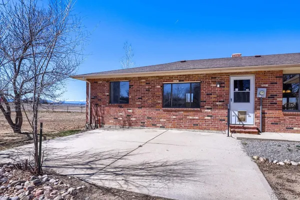 a view of a house with snow on the side of the road