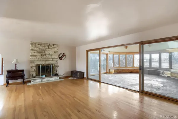 wooden floor fireplace and windows in an empty room