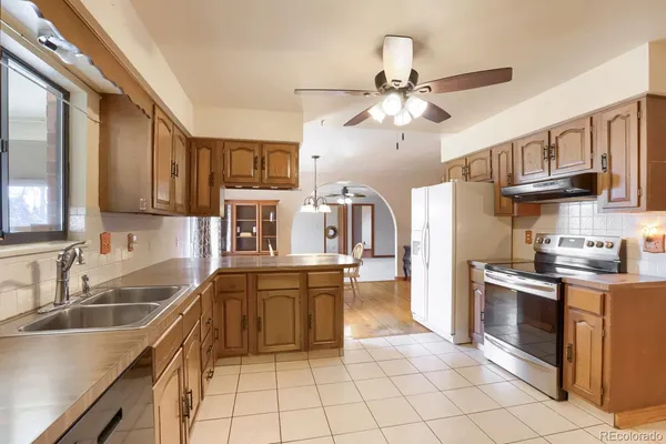 a kitchen with kitchen island granite countertop a sink appliances cabinets and furniture
