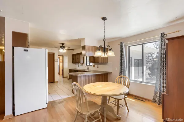 a dining room with furniture a chandelier and wooden floor