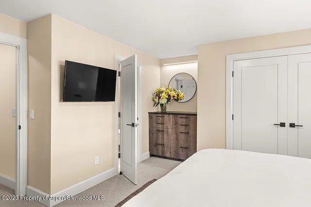 a bedroom with a bed and a flat screen tv