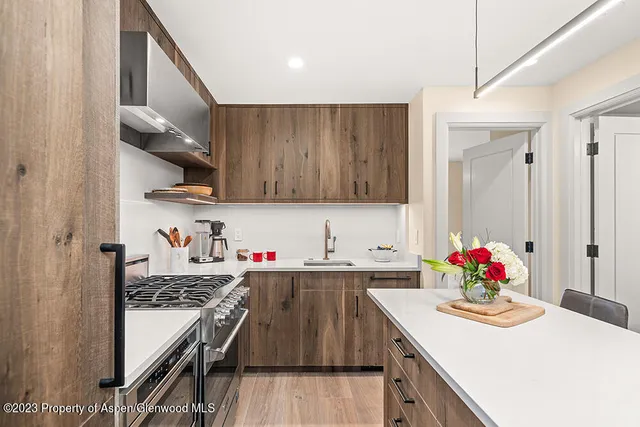 a kitchen with stainless steel appliances a stove a sink and cabinets