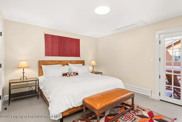 a bedroom with a bed and a lamp on the dresser