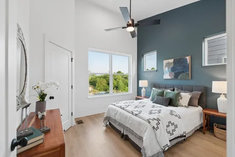 a bedroom with a bed chandelier and a window