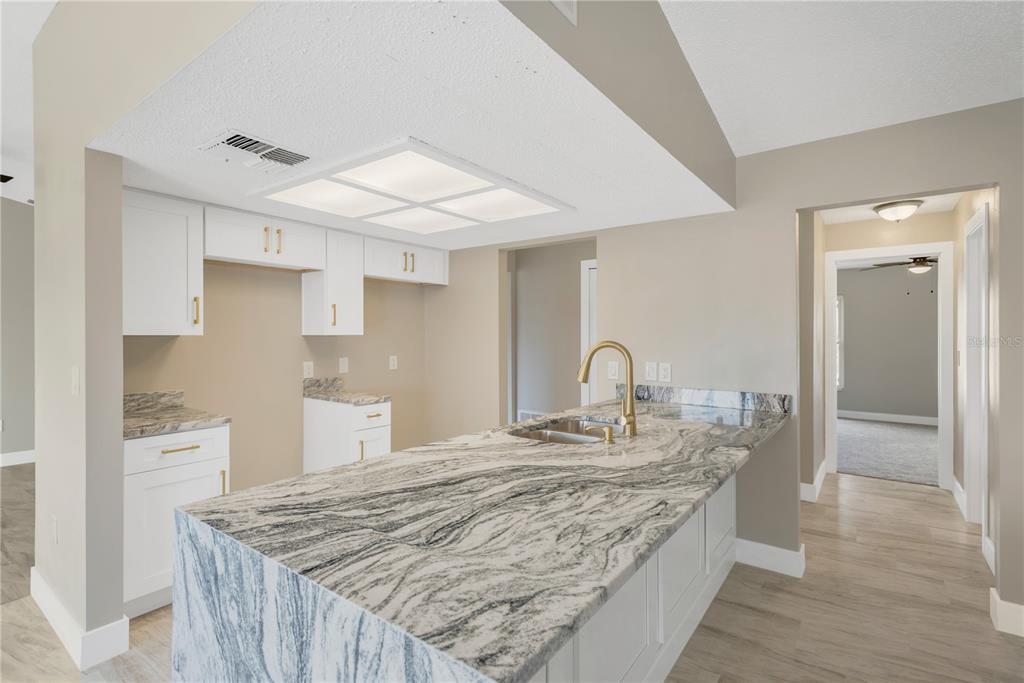 9840 San Sebastian Way Port Richey, FL 34668 - Photo 15 of 45 a large kitchen with kitchen island a sink stainless steel appliances and cabinets