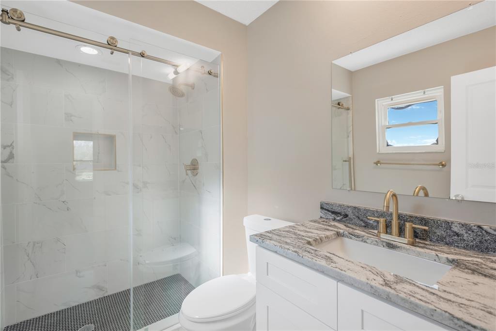 9840 San Sebastian Way Port Richey, FL 34668 - Photo 19 of 45 a bathroom with a granite countertop sink toilet and shower