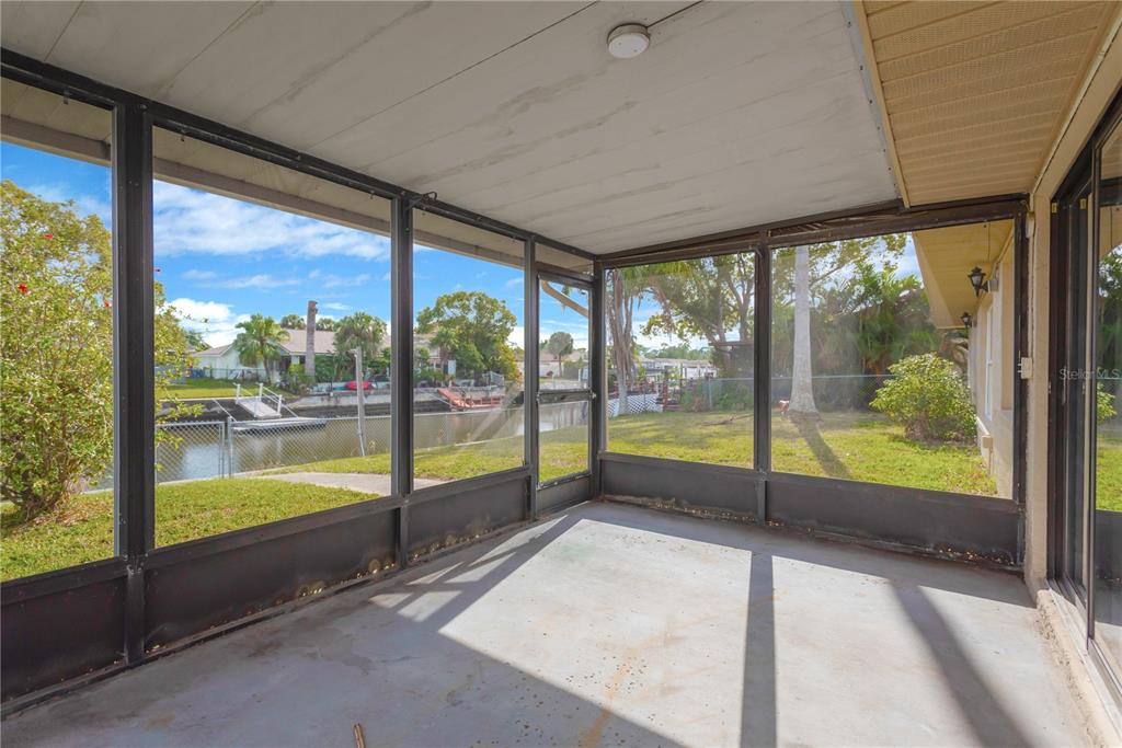 9840 San Sebastian Way Port Richey, FL 34668 - Photo 25 of 45 a view of an empty room with wooden floor and a floor to ceiling window