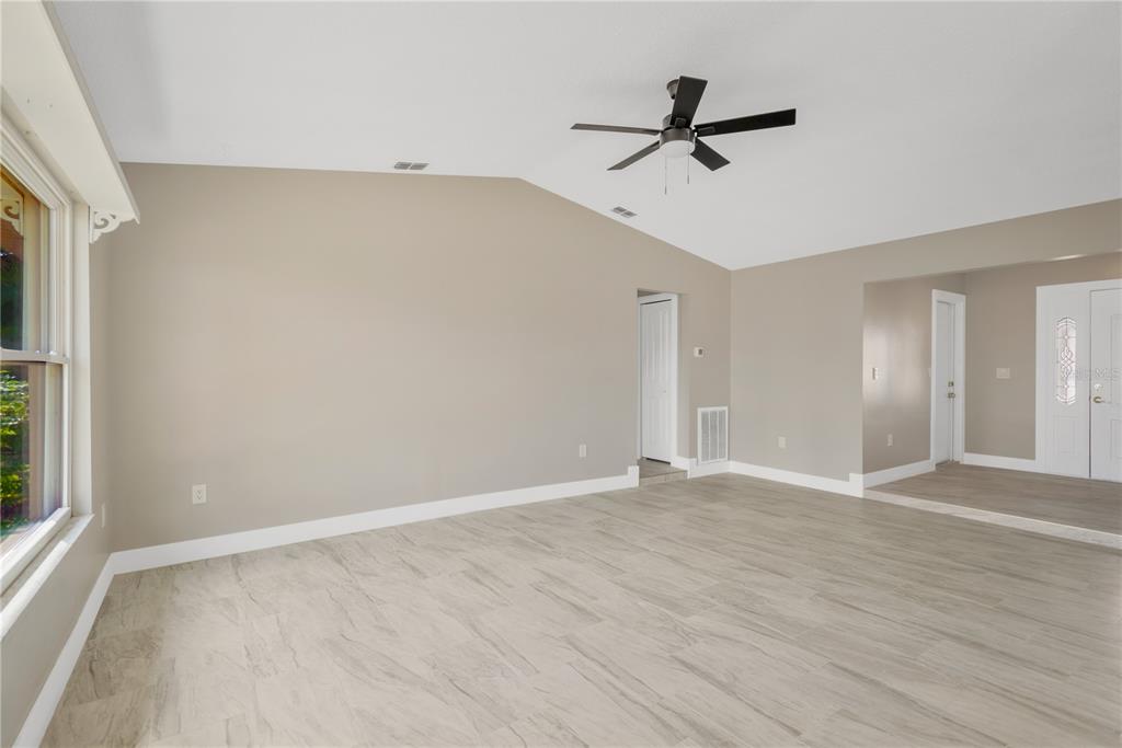 9840 San Sebastian Way Port Richey, FL 34668 - Photo 7 of 45 a view of a livingroom with wooden floor and a ceiling fan