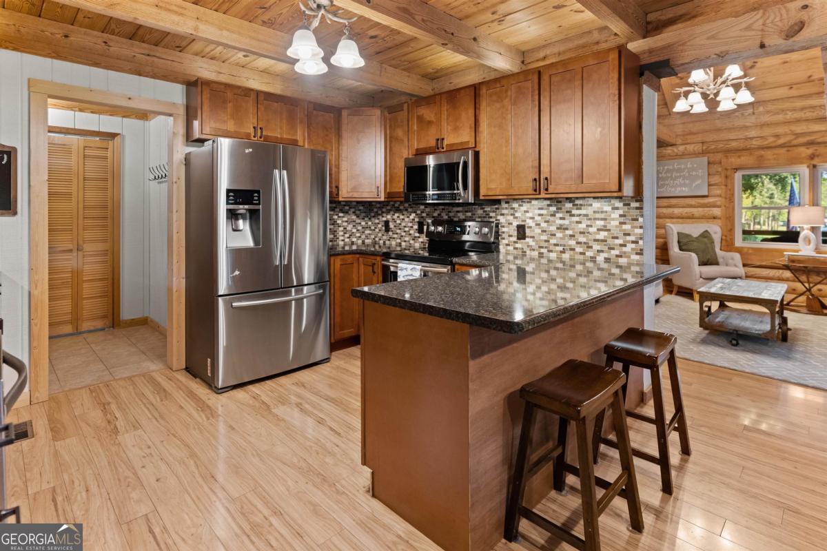 224 Loch Way Eatonton, GA 31024 - Photo 11 of 59 a kitchen with granite countertop a refrigerator and a stove top oven