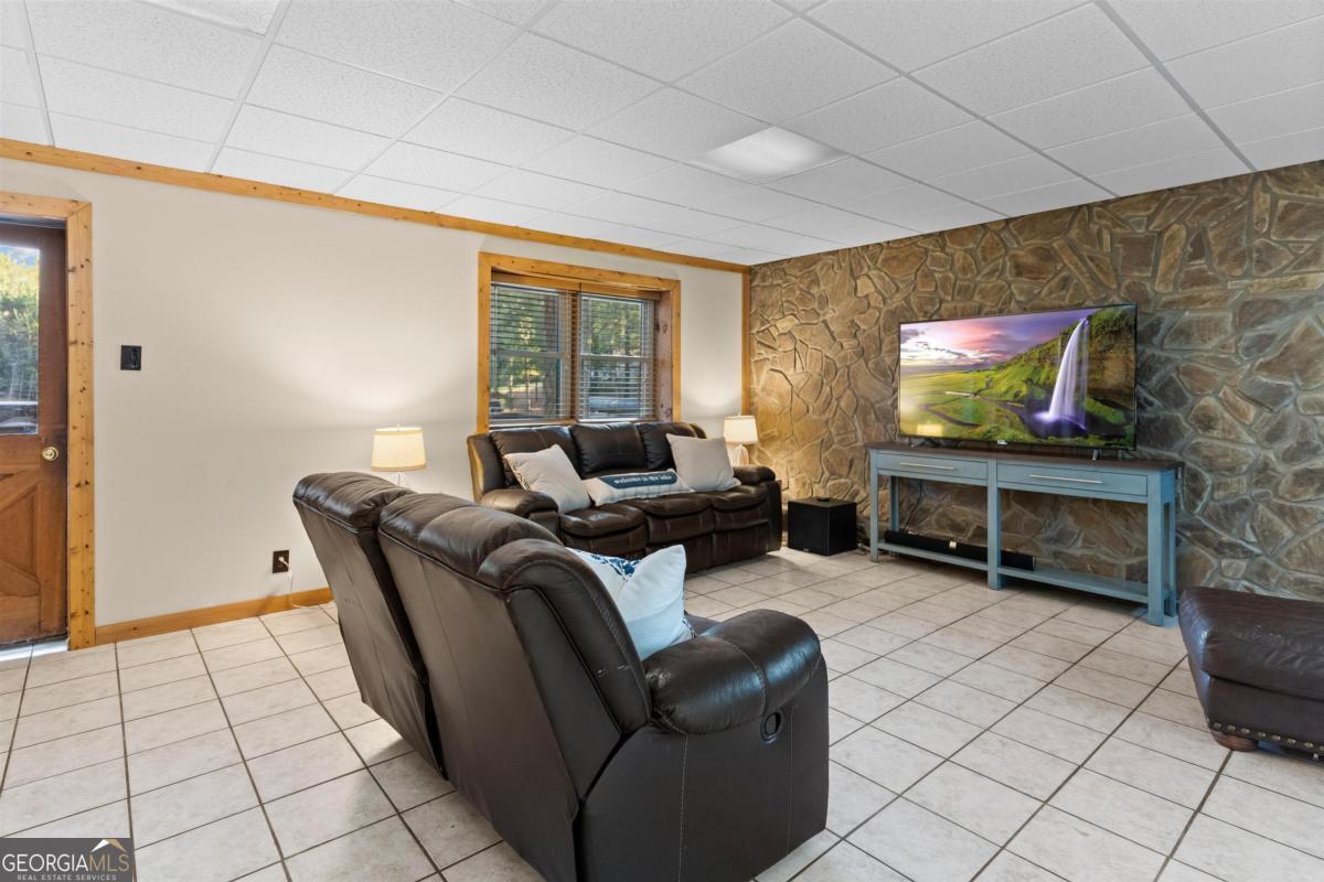 224 Loch Way Eatonton, GA 31024 - Photo 30 of 59 a living room with furniture a flat screen tv and floor to ceiling window