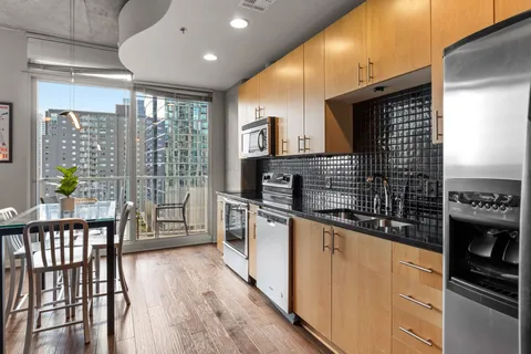 a kitchen with stainless steel appliances granite countertop a stove a sink and a refrigerator