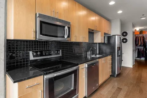 a kitchen with granite countertop a stove and a microwave