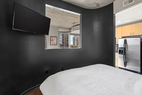 a bedroom with a bed and a potted plant